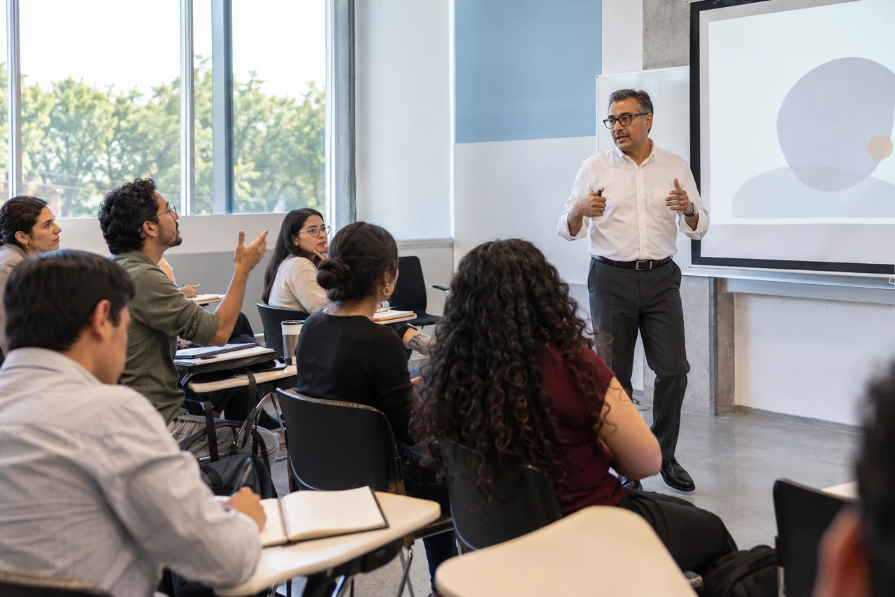 Escena ilustrativa de un seminario presencial con un docente y profesionales del derecho.